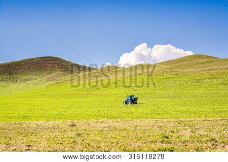 Tractor On Green Meadow With Blue Sky In Turkey, Near Agri