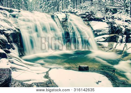 Light Dusting Of Snow Creating A Winter Scene At The Mumlavsky Waterfall At Mumlava River.