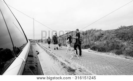 Overveen, Netherlands - Aug 16, 2018: View From The Car On The Family With Dogs Walking On The Walka