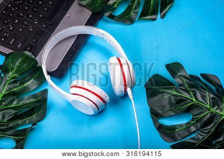 White Red Music Headphones On Technology Background Notbook Computer On A Blue Background. Happy Hol