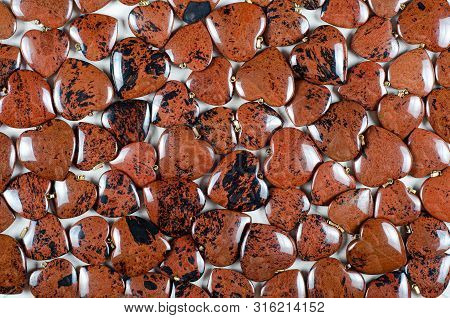 Many Heart-shaped Semi-precious Stones Of Mahogany Obsidian As Background. Top View.