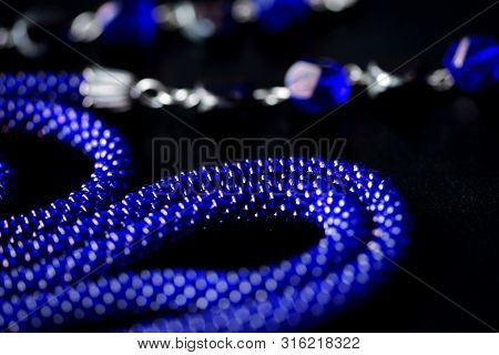 Long Open Necklace (lariat) Blue Color On A Dark Background Close Up