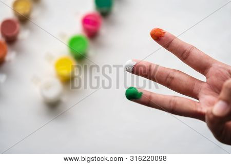 Closeup Shot Of Person Showing Hands Painted With Orange Or Saffron, White, Green With Water Colours