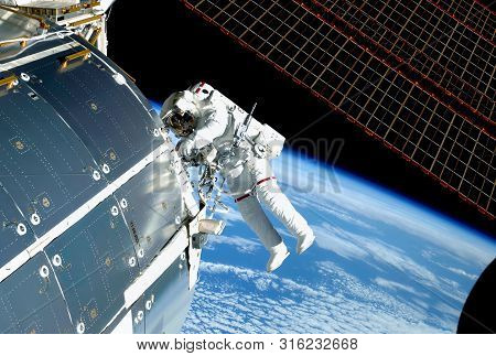 The Astronaut In An Outer Space, At The Iss, Repairs And Makes Experiments. Elements Of This Image W