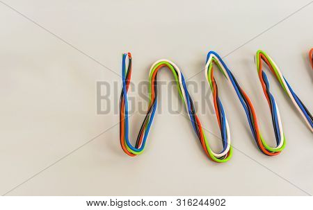 Electric Wires Of Different Colors In Curved Form On A Gray Background