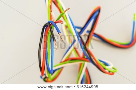 Electric Wires Of Different Colors In Curved Form On A Gray Background