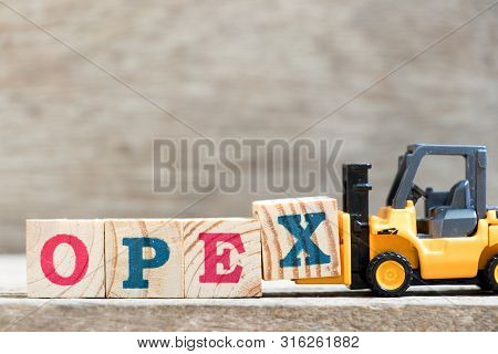 Toy Forklift Hold Letter Block X In Word Opex (abbreviation Of Operating Expense) On Wood Background