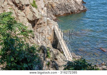 The Bridge Goes From One Rock To Another. It Seems That The Bridge Stops In The Air