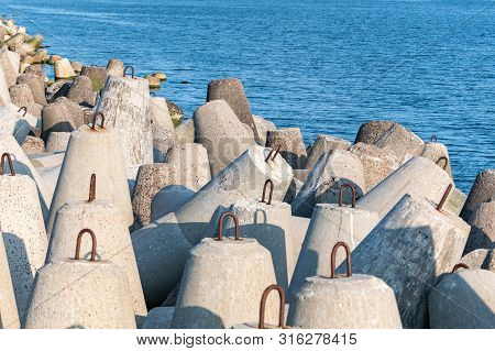 Breakwaters In Sea. Beautiful Sunset Seascape With Concrete Tetrapodes For Protect Coastal Structure