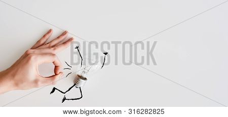 Female Hand Near Light Bulb. Ceative Concept.