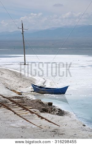 Salt Lake landscape with blue boat, named Chaka Salt Lake, is located in Qinghai Province, China.                 