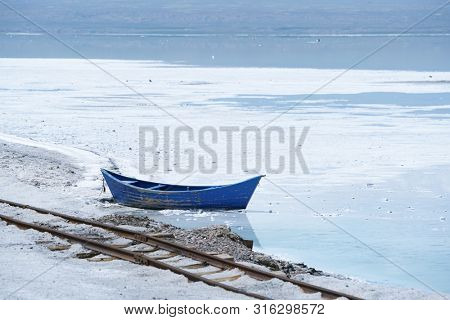 Salt Lake landscape with blue boat, named Chaka Salt Lake, is located in Qinghai Province, China.                 