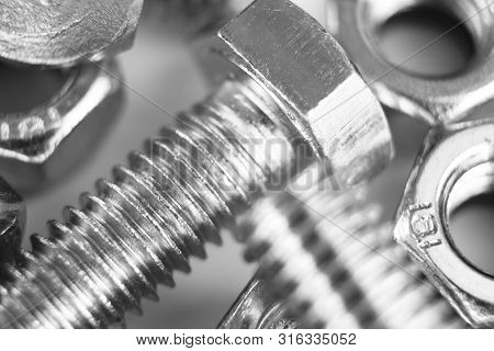 Metal Bolts And Nuts  In A Row Background. Chromed Screw Bolts And Nuts Isolated. Steel Bolts And Nu