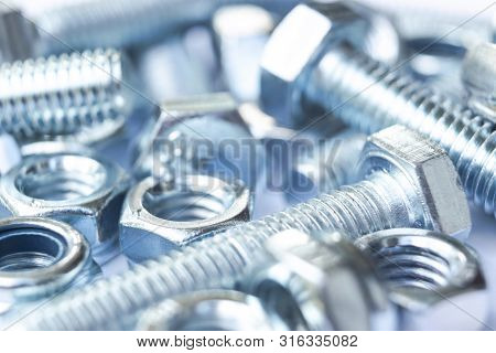 Metal Bolts And Nuts  In A Row Background. Chromed Screw Bolts And Nuts Isolated. Steel Bolts And Nu