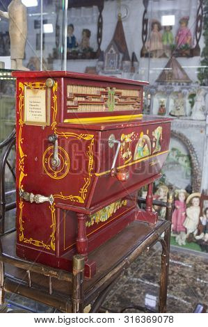 Russia, Krasnoyarsk, July 2019: A Barrel Organ At A Christmas Market. Wooden Hurdy-gurdy.