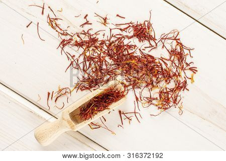Lot Of Whole Dry Shaffron Thread With Wooden Scoop Flatlay On White Wood