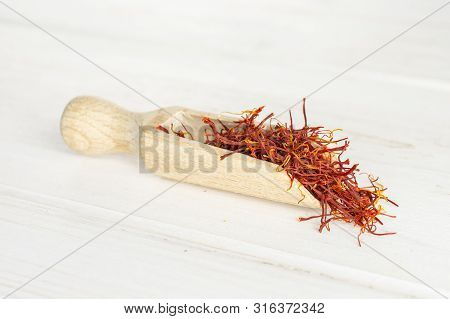 Lot Of Whole Dry Shaffron Thread With Wooden Scoop On White Wood