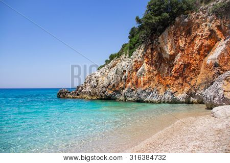 Beautiful Sandy Beach With Rock And Blue Clear Water