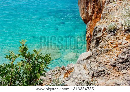Beautiful Sandy Beach With Rock And Blue Clear Water
