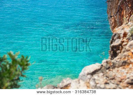Beautiful Sandy Beach With Rock And Blue Clear Water