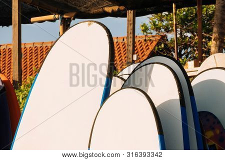Close Up Set Of White And Blue Surfboard For Rent On The Beach. Multicolored Surf Boards Different S