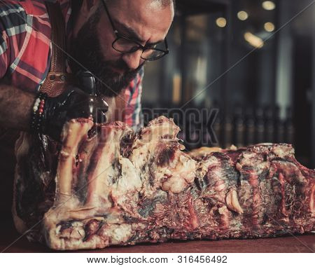 Chef cutting beef carcass in a restaurant