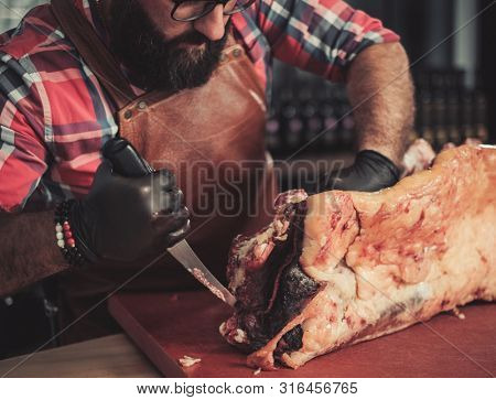 Chef cutting beef carcass in a restaurant