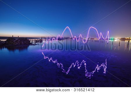 Amazing Laser Fireshow Performance In The Night Blue Sky With Reflections In The Sea Water