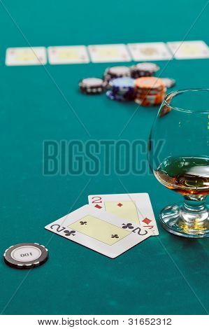 et glas spiritus og kort og dollars