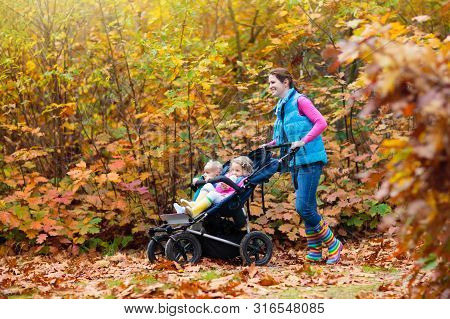Family Hiking With Stroller In Autumn Park