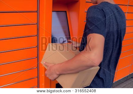 Client Using Automated Self Service Post Terminal Machine Or Locker To Deposit A Parcel For Storage