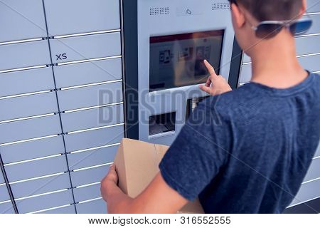 Client Using Automated Self Service Post Terminal Machine Or Locker To Deposit A Parcel For Storage