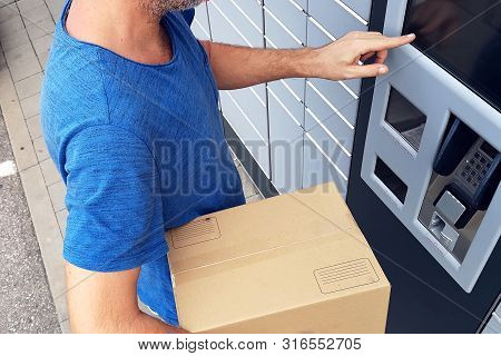 Client Using Automated Self Service Post Terminal Machine Or Locker To Deposit A Parcel For Storage