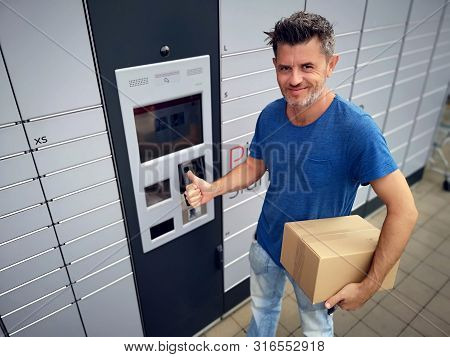 Client Using Automated Self Service Post Terminal Machine Or Locker To Deposit A Parcel For Storage