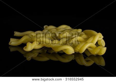 Lot Of Whole Raw Pasta Gemelli Isolated On Black Glass