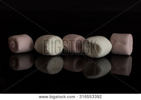 Group Of Five Whole Pink And White Sweet Fluffy Marshmallow Isolated On Black Glass