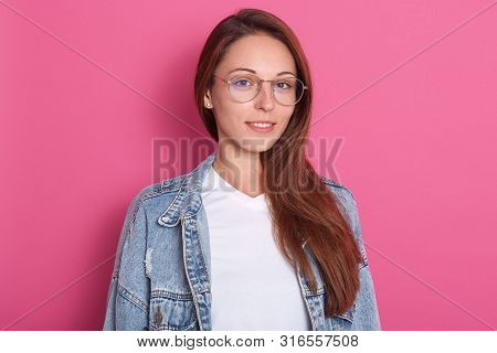 Indoor Shot Of Pleasant Looking Woman, Smiles Positively, Wearing Optical Glasses, White T Shirt And