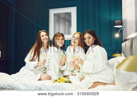 Young Women In White Bathrobe With Champagne Glasses At A Spa Party
