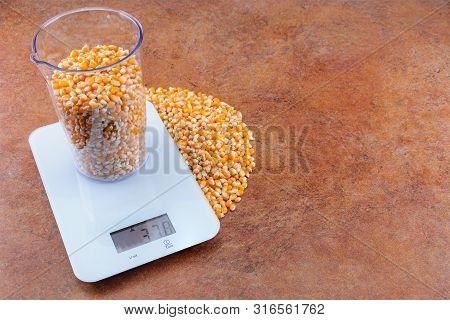 Corn In A Transparent Measuring Cup Weighed On White Electronic Weighing The Weight Of 500 Ml Of The