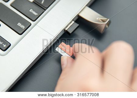 Woman's Hand Puts In Fast, Capacoius Microsd Card To The Modern Ultrabook.