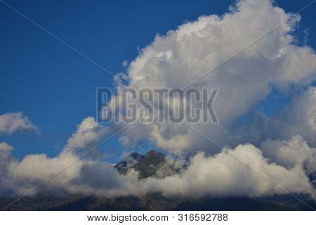 A Panoramic View Of The Bhutan Mountain In Bhutan Capped By Big White Clouds