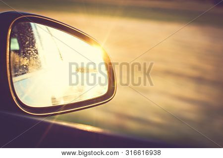 Side Mirror In A Car In Which The Sunset Is Reflected.