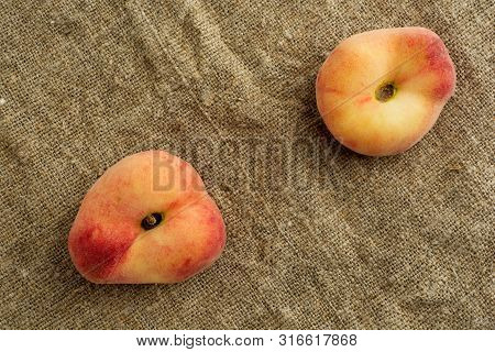 Donut Peaches Also Known As Saturn Peaches On A Rustic Canvas Background. Healthy Food Consept.
