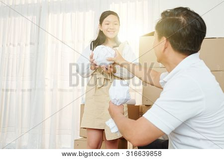 Cheerful Pretty Preteen Vietnamese Girl Helping Father With Packing Belongings Anf Moving Out