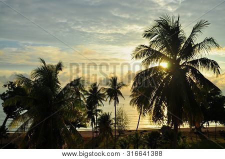 Scenic View Of Desaru Beach (located In Malaysia) With Sunrise In The Background, And Palm Trees In 