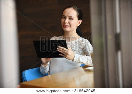 Young Happy Woman Working With Tablet Drinking Coffee, Sitting In Street Cafe