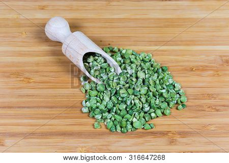 Ripe Split Peas Of Green Variety In Wooden Spice Spoon And Scattered Beside Her On A Bamboo Wooden S