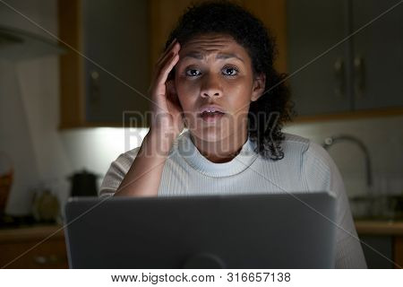 Portrait Of Unhappy Woman At Home With Computer Victim Of Online Crime