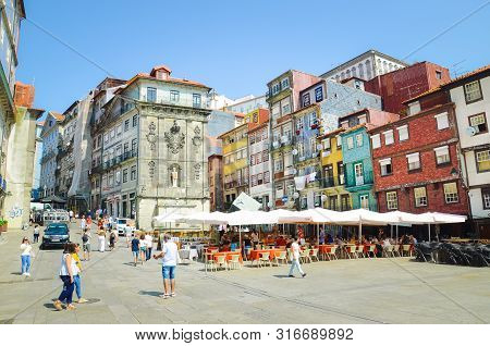 Porto, Portugal - August 31 2018: People On Promenade By River Douro On Sunny Day. The Embankment Is