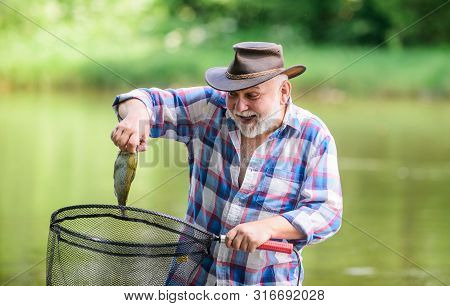 Fish Farming Pisciculture Raising Fish Commercially. Fisherman Alone Stand In River Water. Man Senio
